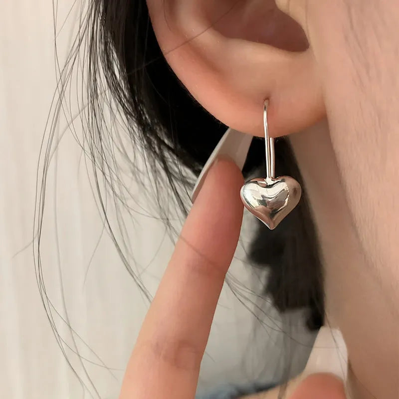 Silver-coloured heart-shaped earrings with three-dimensional glossy design and Korean style aesthetics
