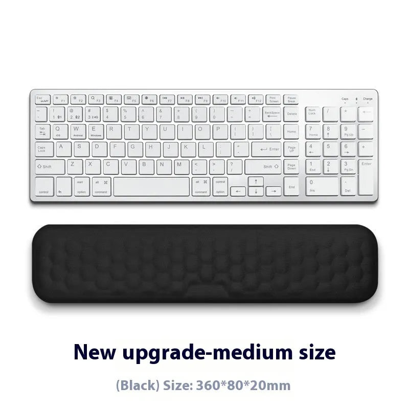 Customisable memory foam mouse wrist pad with black cloth cover on a desk.