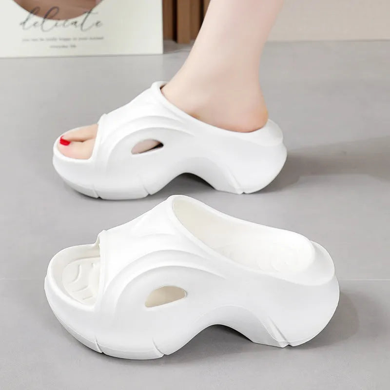 Women's white EVA slippers with thick sole and round toe on a beach background
