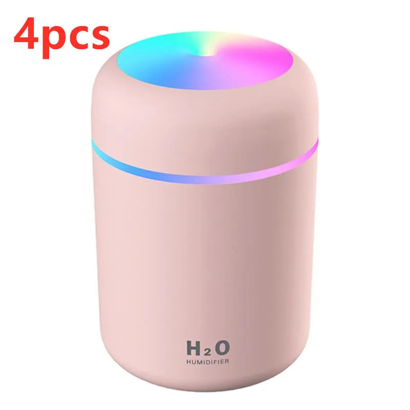 Pink USB portable humidifier with 300ml water tank on wooden desk surface