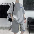 Man wearing a grey waffle-textured cotton leisure sports suit with short sleeves and shorts.
