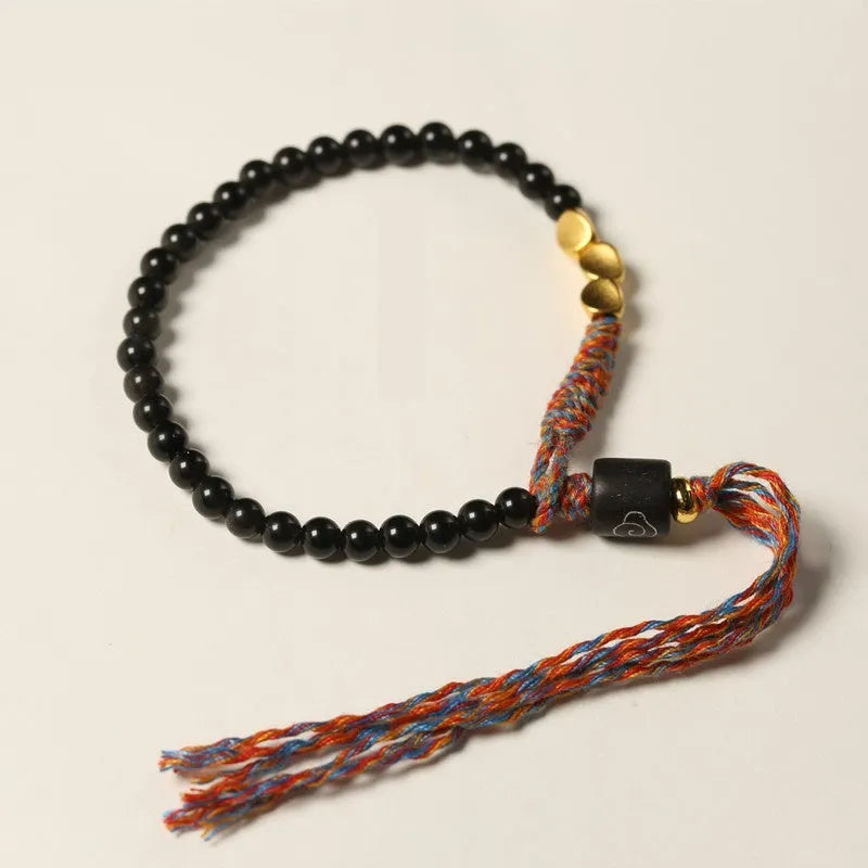 Hand-woven obsidian carrying strap bracelet showing textured weave and adjustable 15.5-16cm length