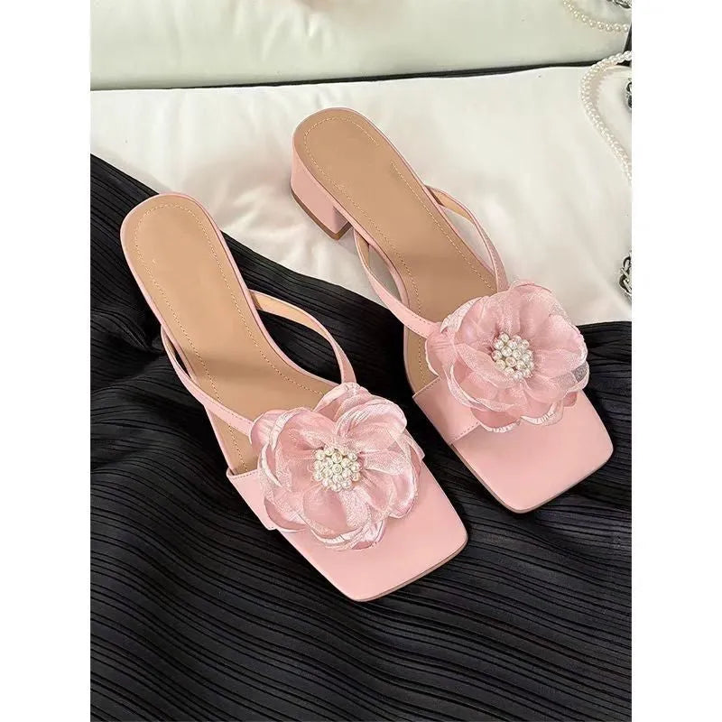 Women's cream-white satin sandals with a chunky heel and square toe on a light background.