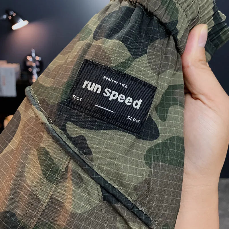 Man wearing loose fit camouflage cargo shorts made from quick-drying cotton blend fabric.