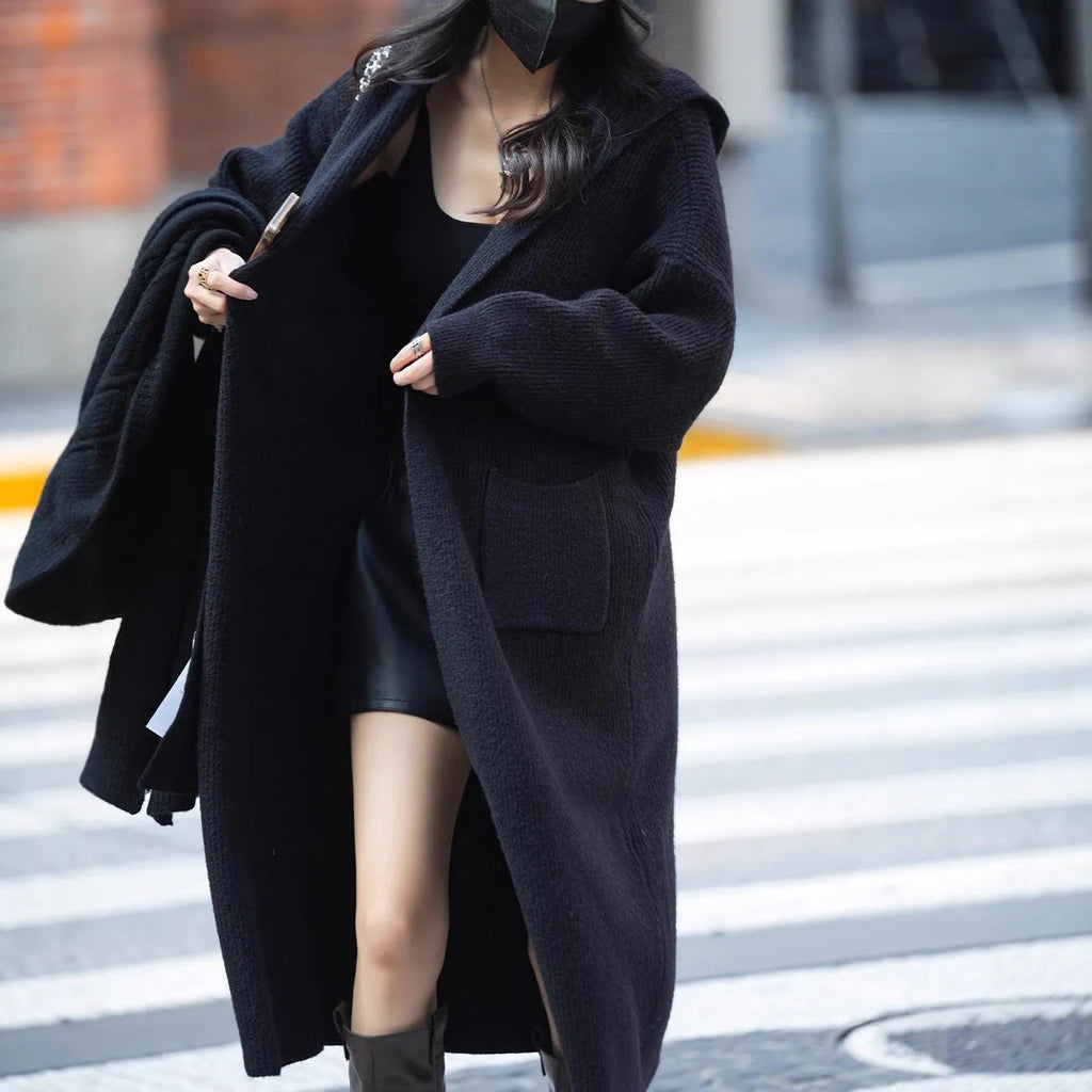 Women's long grey knitted cardigan hooded trench coat on a hanger.