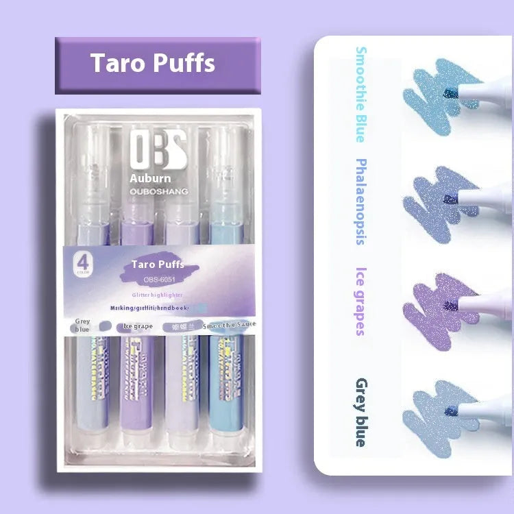 Four glitter highlighter pens with pastel colours and slanted tips on a notebook.