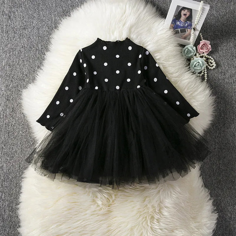 Baby girl wearing a long sleeve black lace tutu dress for a christening or birthday party.