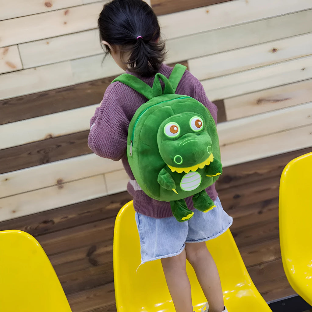Soft blue plush dinosaur backpack for kids with embroidered character detail and a soft handle.