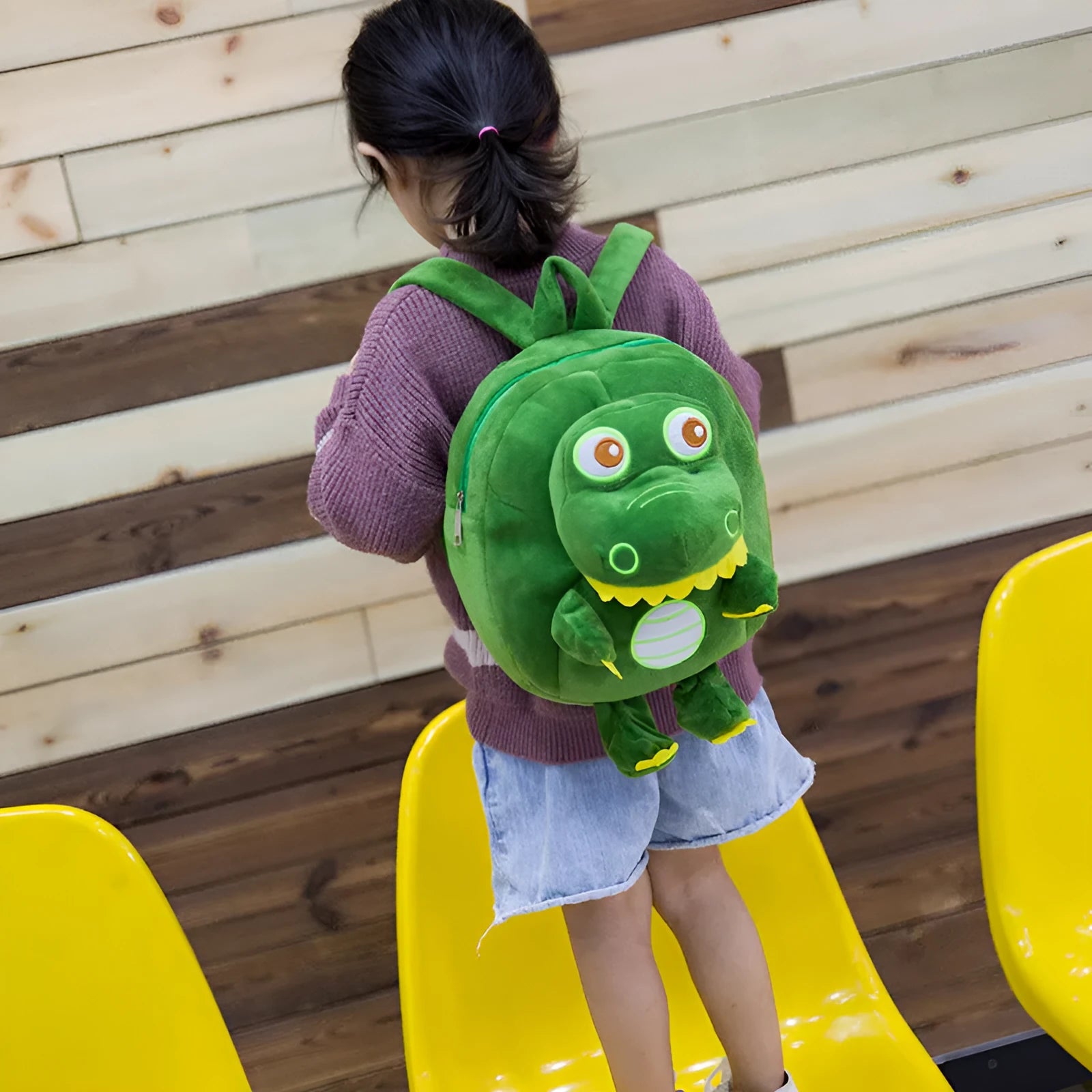 Soft blue plush dinosaur backpack for kids with embroidered character detail and a soft handle.
