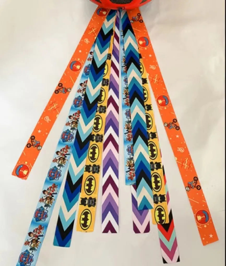 Close-up of a colourful decorative ribbon streamer attached to a child's helmet for roller skating or skiing.