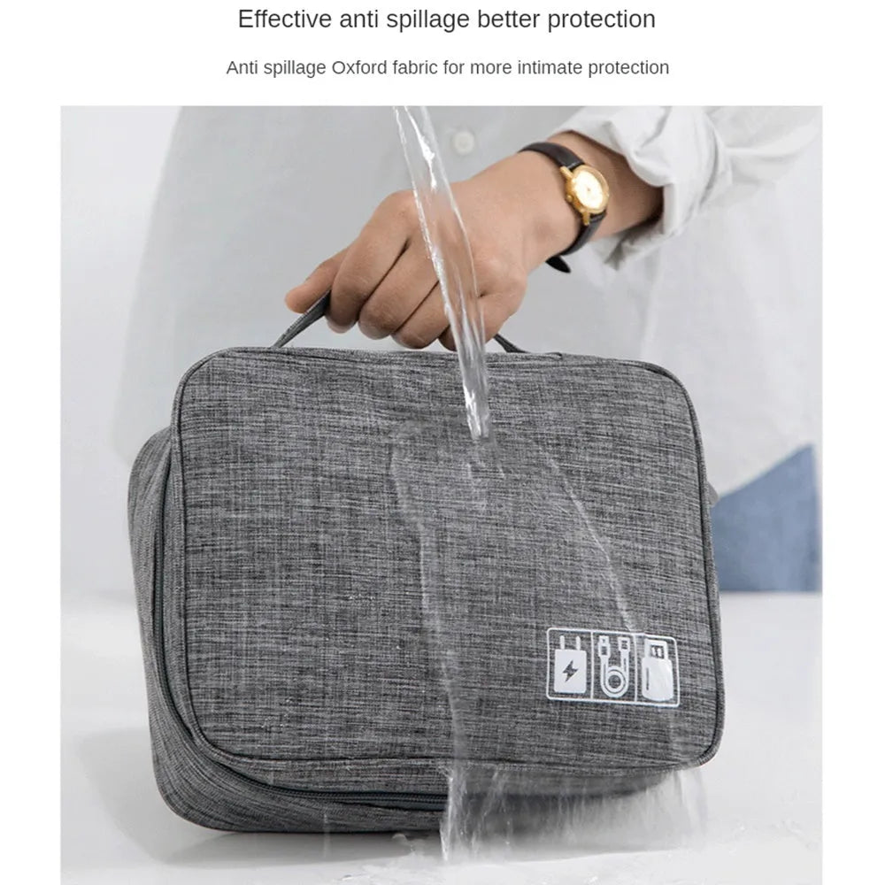 Black waterproof electronics organiser bag open, showing mesh pockets, elastic loops and removable dividers.