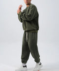 Men's black polar fleece sports suit with loose crew neck jacket and padded trousers on a hanger.