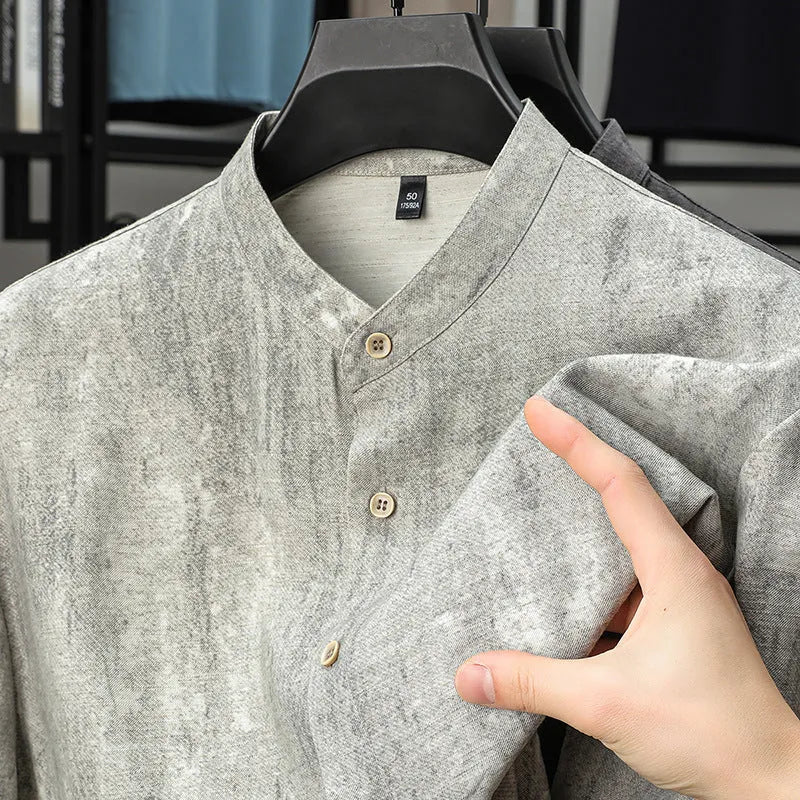 Man wearing a loose grey linen shirt with a stand collar and short sleeves, cardigan style.