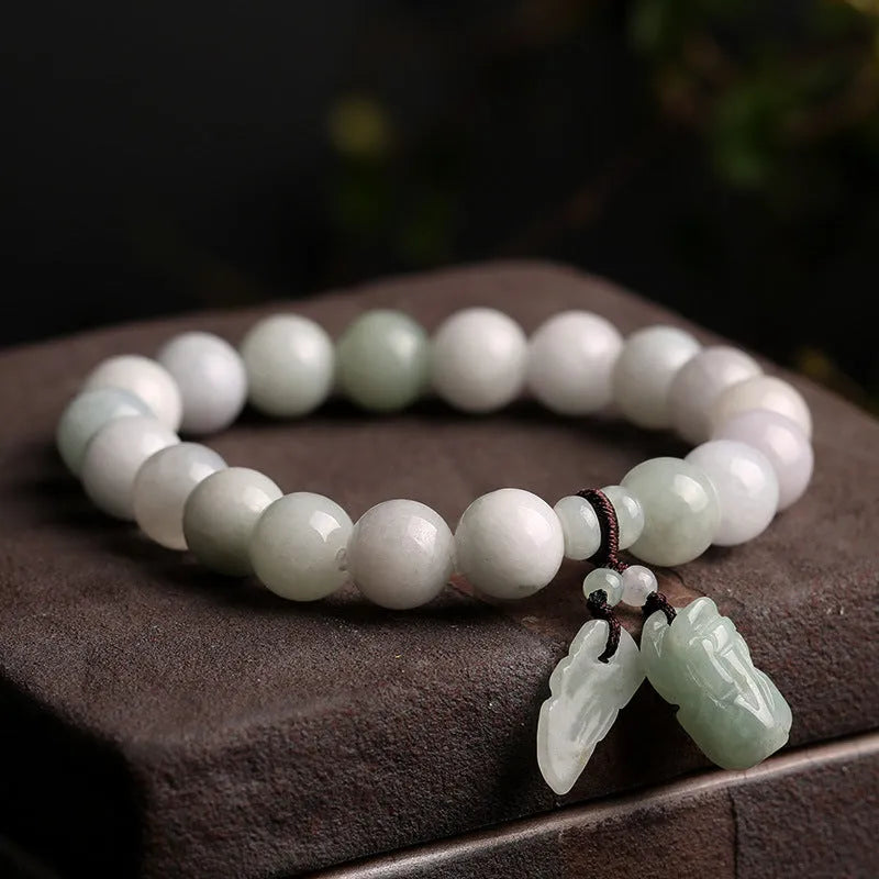 Emerald green jade bracelet with hanging symbolic charms including Maitreya Buddha design