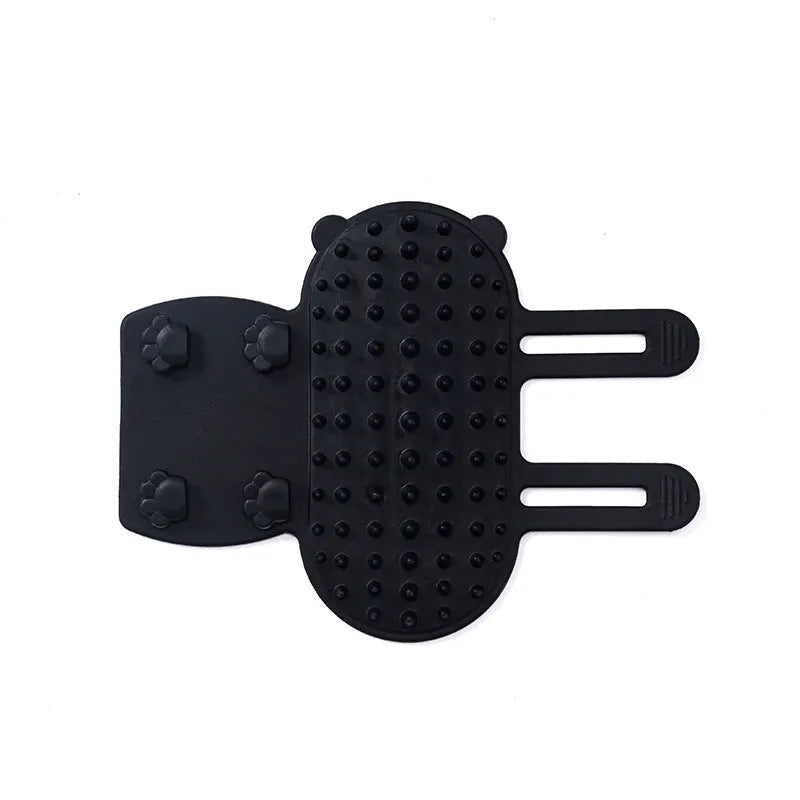Silicone cat grooming comb with adjustable strap mounted on a table leg, shown in green colour.