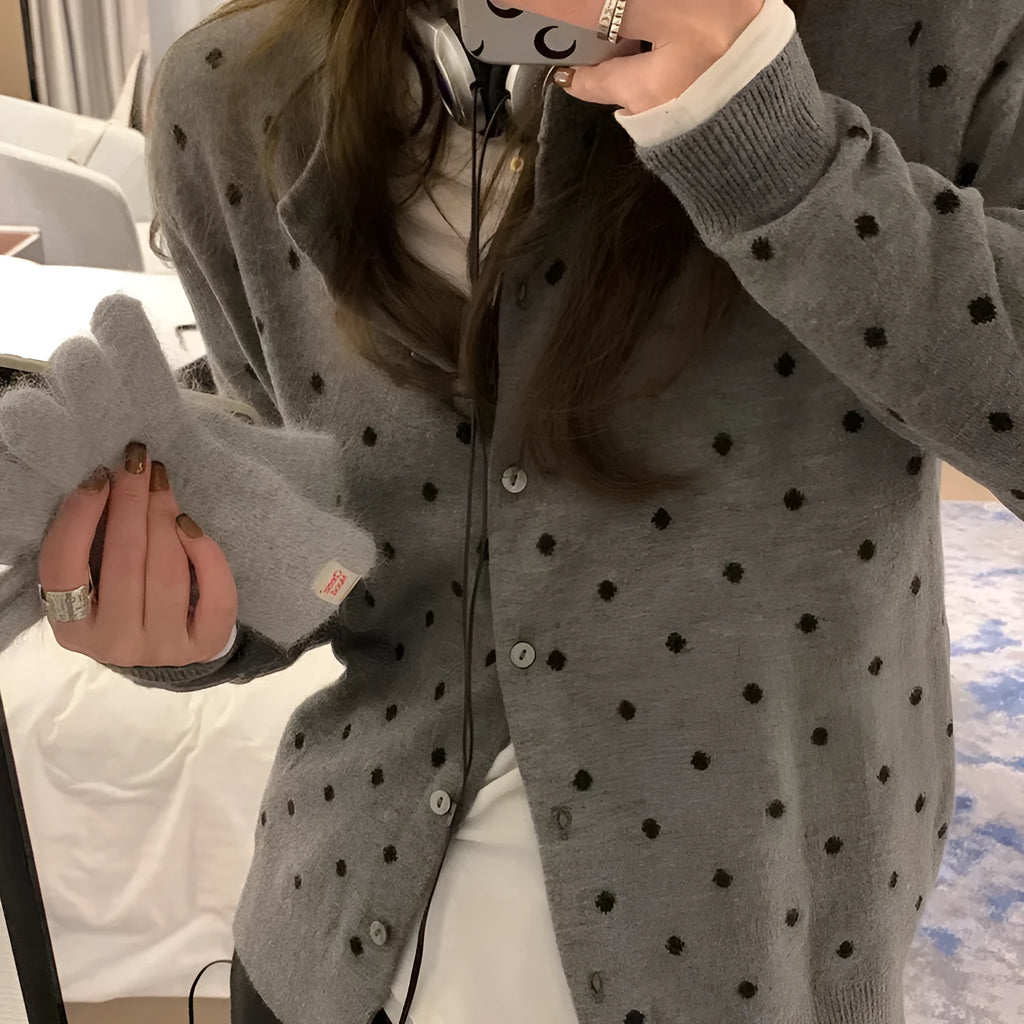 Grey dot knitted women's cardigan with crocheted flower details on the front.