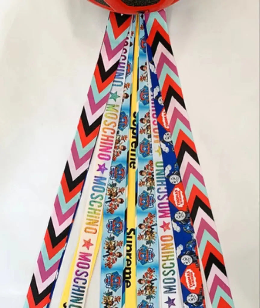 Close-up of a colourful decorative ribbon streamer attached to a child's helmet for roller skating or skiing.