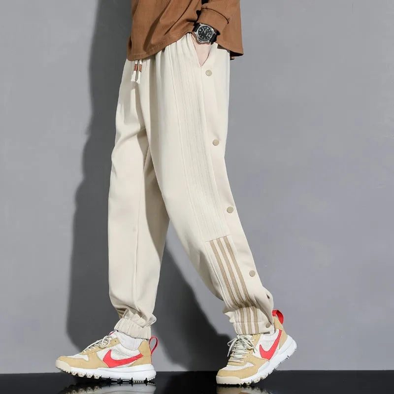 Men's black loose-fit sweatpants with ankle ties and a drawstring high waist on a neutral background.
