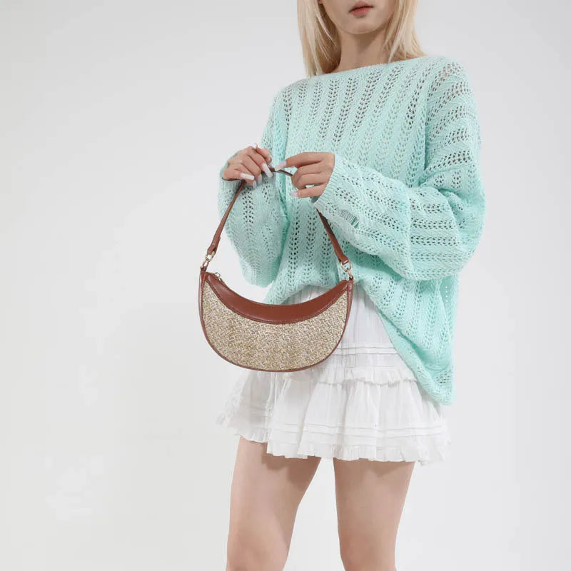 Hard woven straw dumpling-shaped crossbody shoulder bag with organised interior compartments.