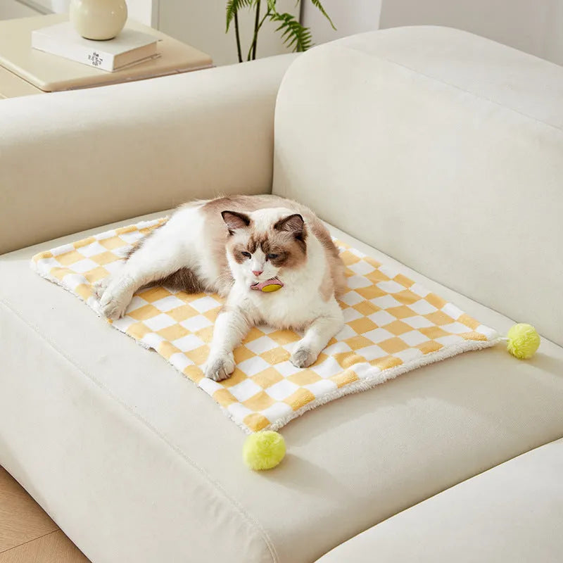 Green plaid pattern pet blanket with soft fleece texture on sofa