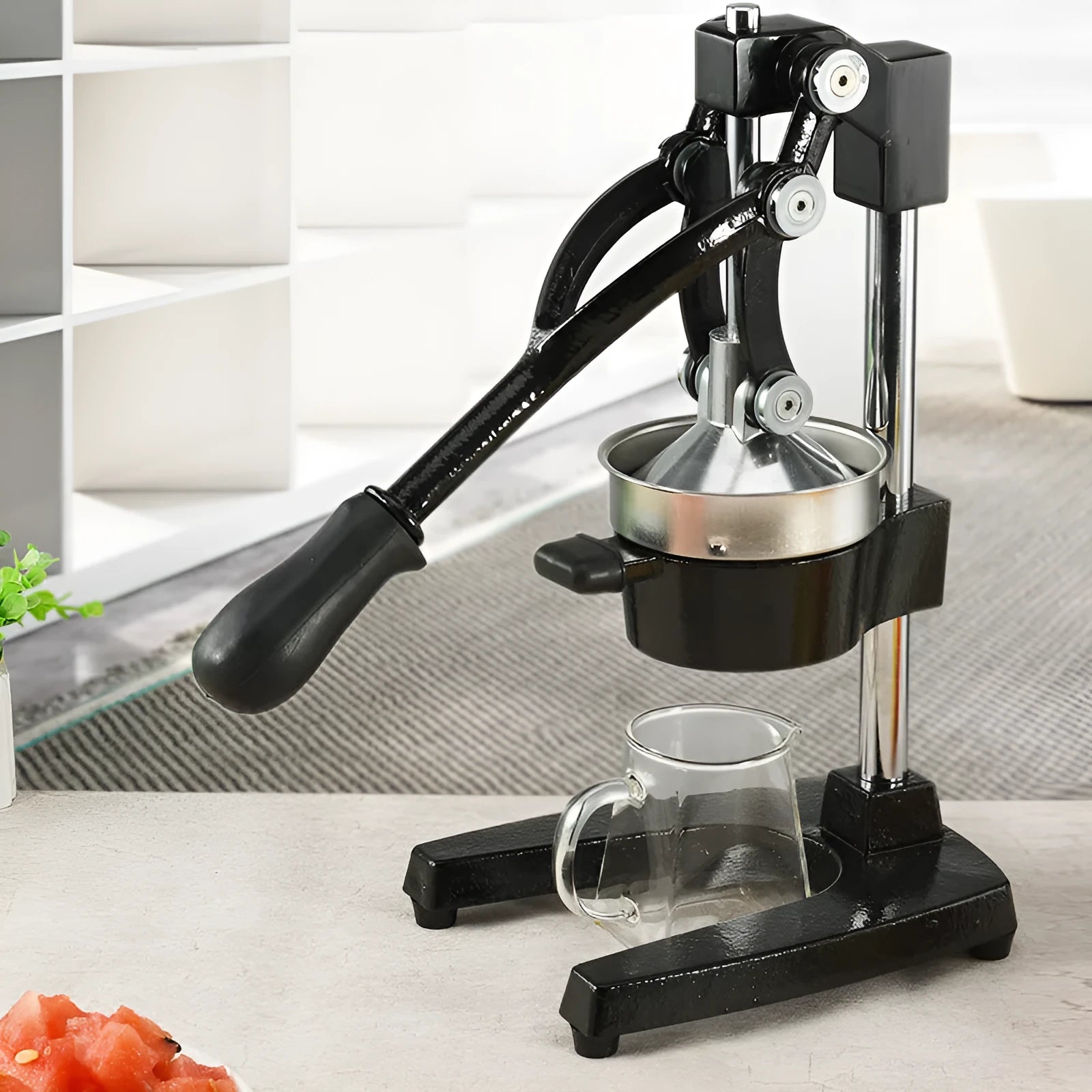 Black cast iron manual citrus juicer with stainless steel cone on a white background.