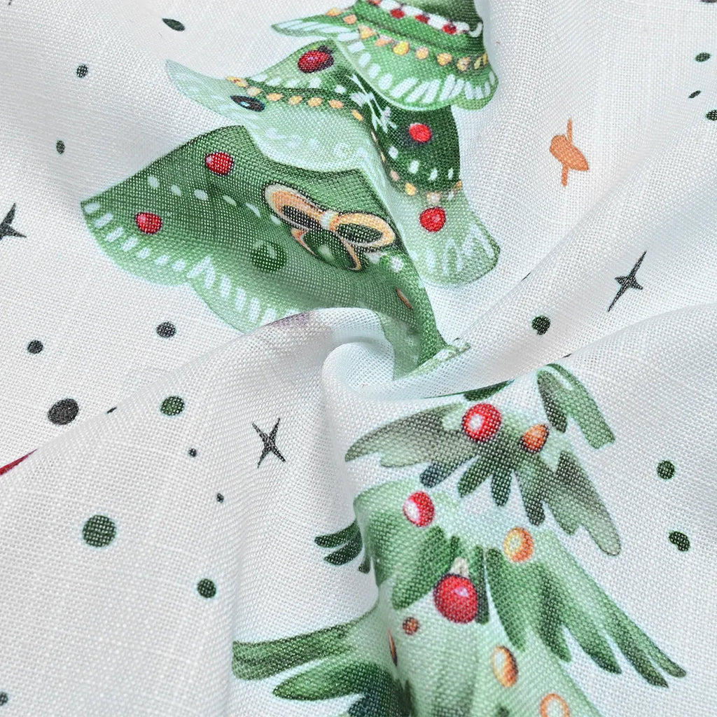 Close-up of a white polyester curtain with a punched Christmas tree forest pattern, showing its texture and light-filtering quality.