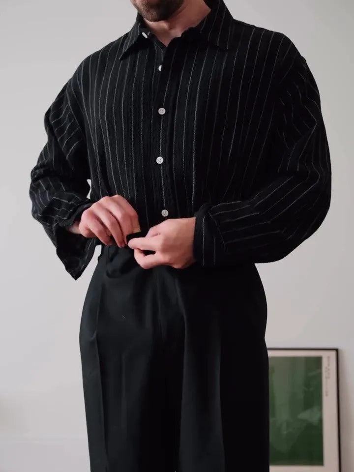 Black and white pinstriped long sleeve button-down shirt on a hanger.