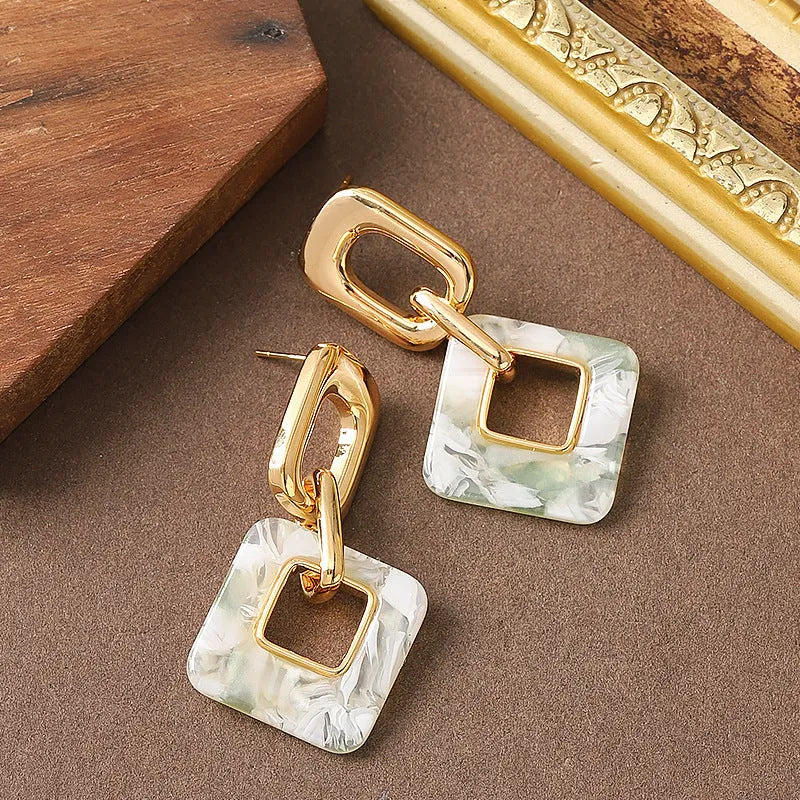 Hollow geometric square earrings with chamfered corners in metallic finish