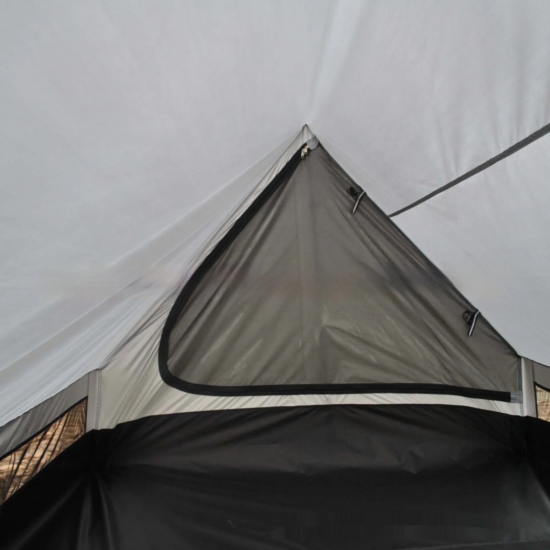 Brown or white A-line hiking tent without poles, supported by hiking canes