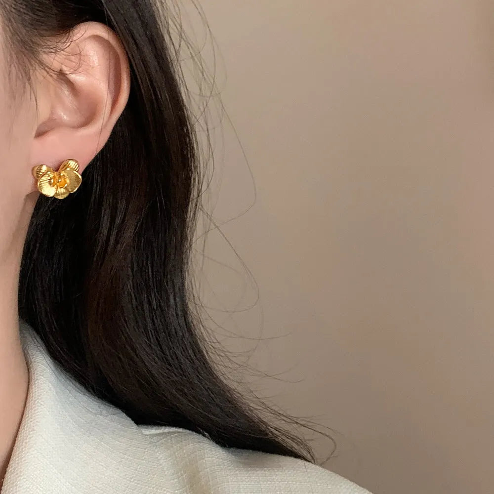 Retro floral fashion earrings in gold or silver colour with petal detailing on copper base.