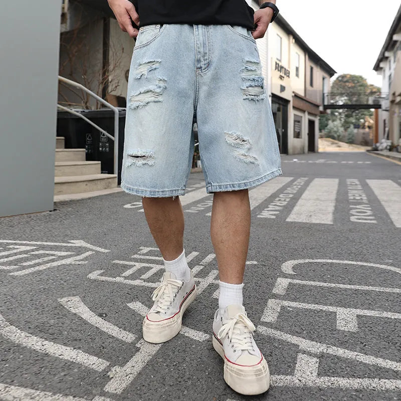 Light blue ripped denim shorts with distressed detailing and loose straight cut fit