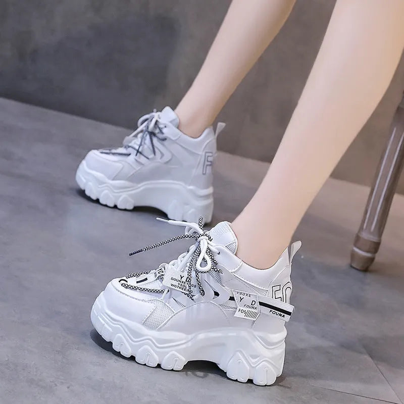 Women's white and black mesh platform sports shoes with cross-strap and rubber sole.