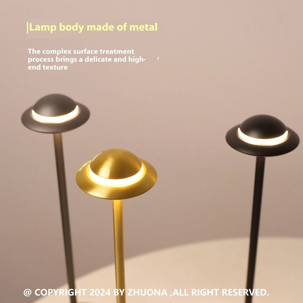 Gold UFO-shaped metal table lamp with touch dimming controls on a desk.