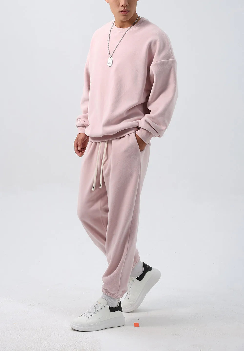 Men's black polar fleece sports suit with loose crew neck jacket and padded trousers on a hanger.