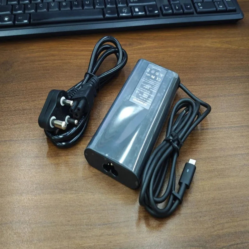 Black 65W Type-C laptop power adapter with a set of interchangeable international plug heads.