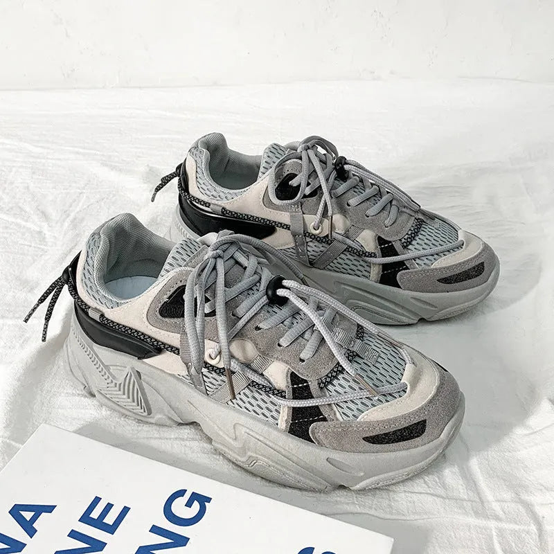 Men's black platform dad shoes with white soles and lace-up front, shown on a grey background.