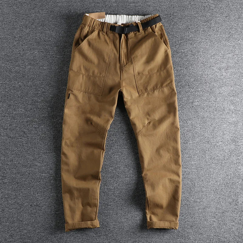 Men's khaki cotton work trousers with three-dimensional cutting and a silver N I buckle belt on the waist.