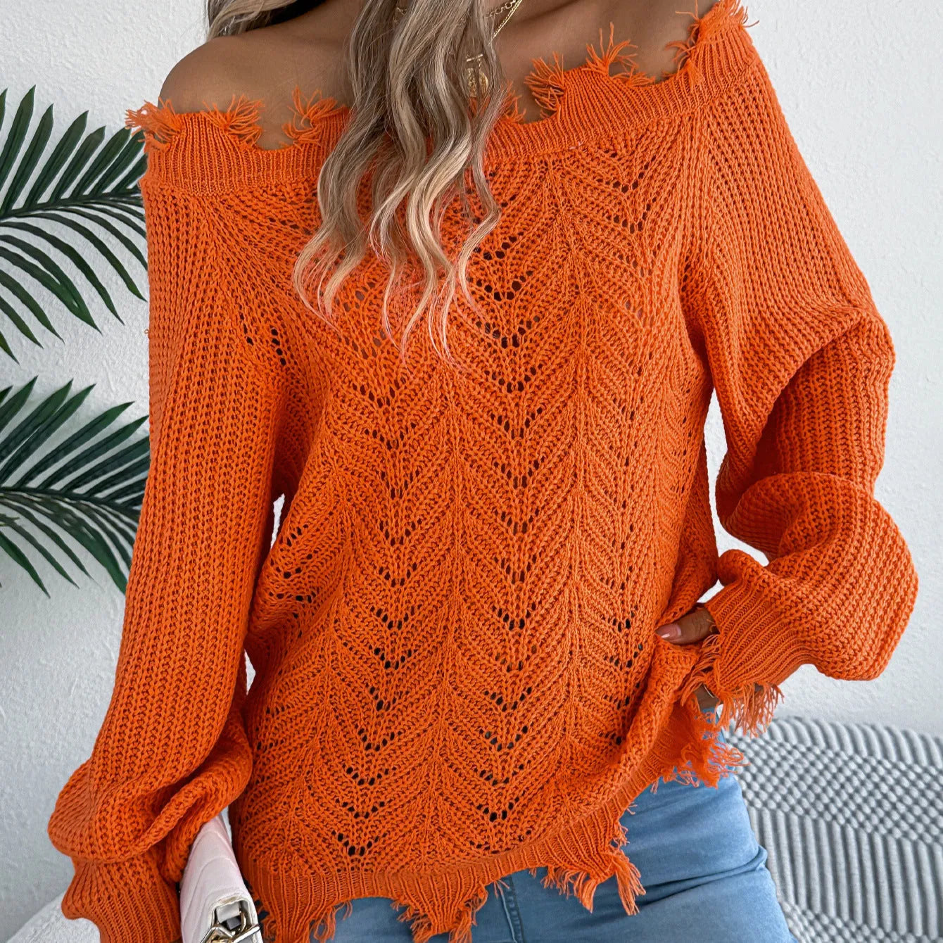 Women's white hollow-out knitted pullover sweater with cut off-the-shoulder neckline and long sleeves.