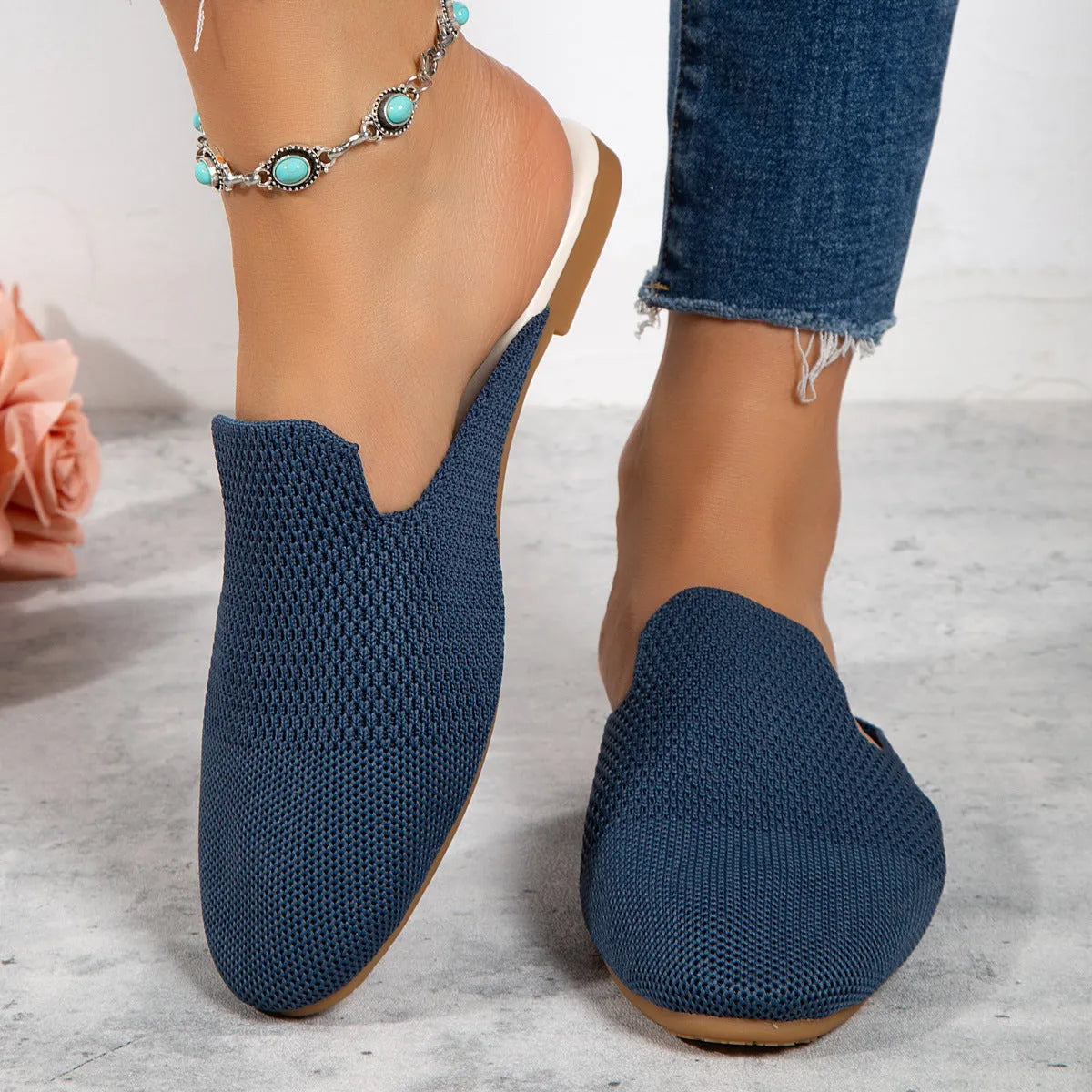 A pair of apricot-coloured mesh slip-on sandals with a cloth upper and flat rubber sole.