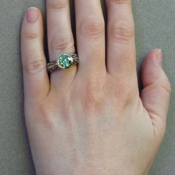 Gold-plated flower-shaped ring with emerald green gemstone in vintage design on finger