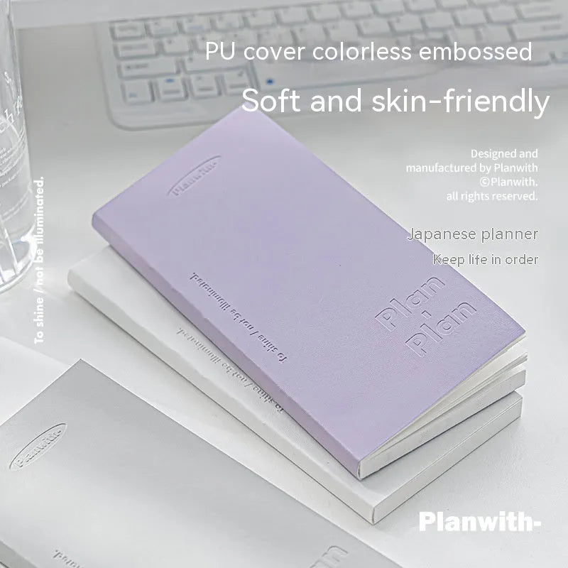 Embossed cover daily meter book notebook open on a desk, showing white 100g paper.