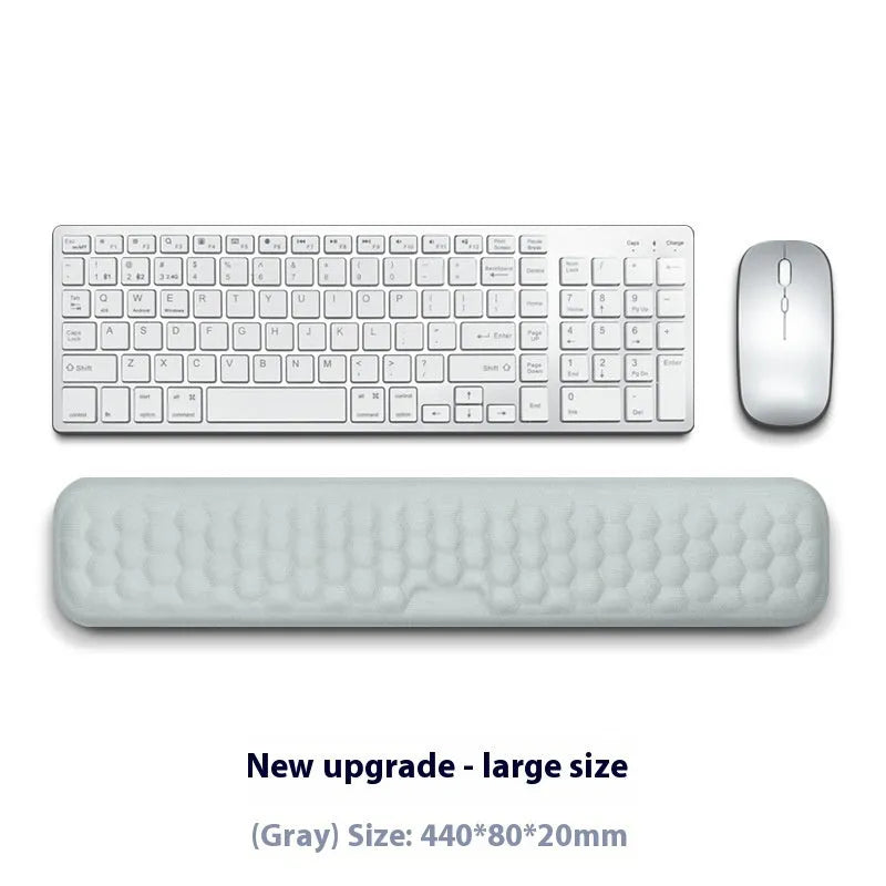 Customisable memory foam mouse wrist pad with black cloth cover on a desk.