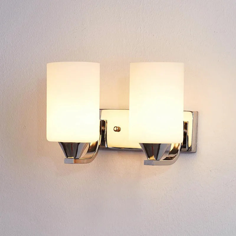 Modern chrome-finished wall lamp with a clear glass shade, shown in a single head configuration.