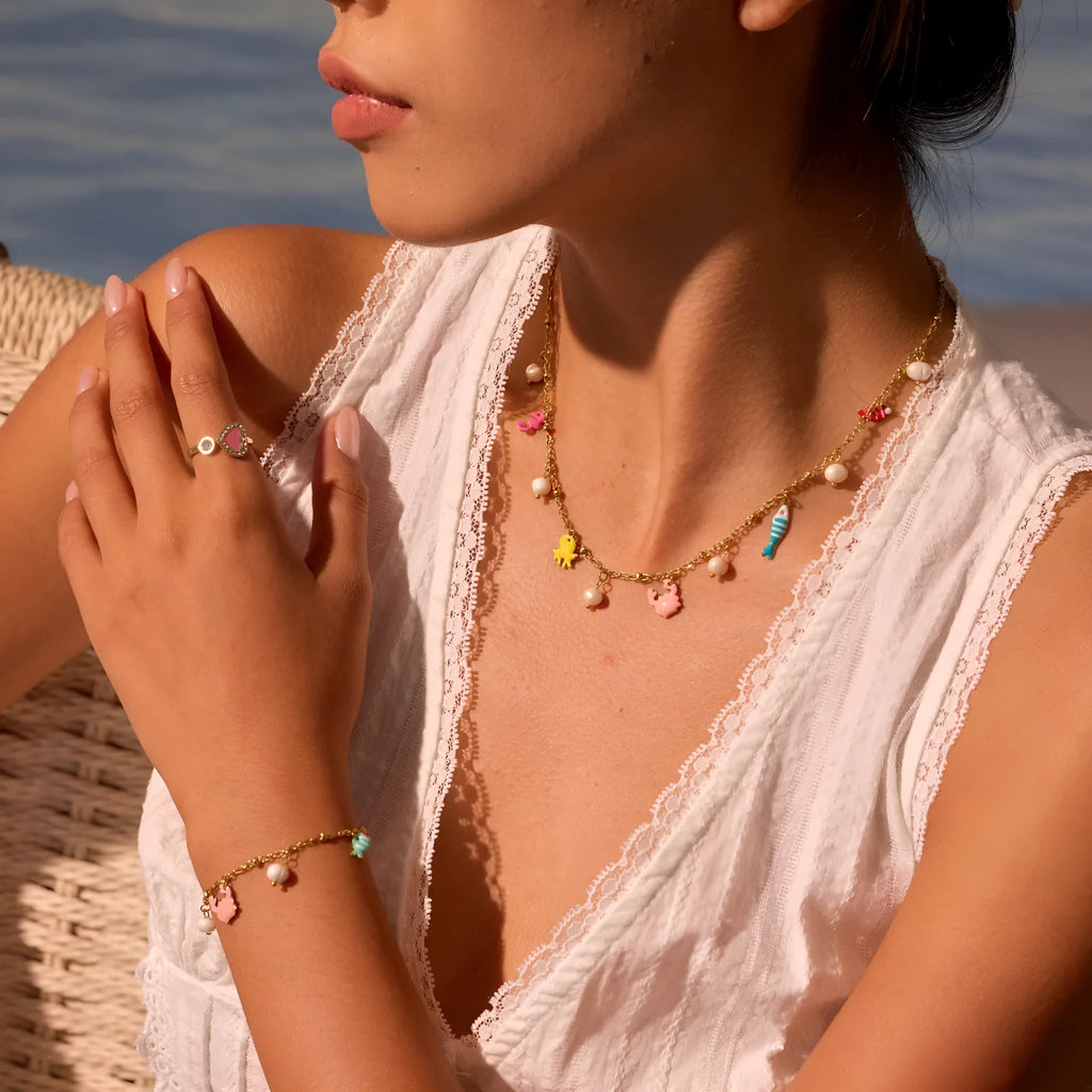 Stainless steel geometric pendant necklace with 18K gold electroplated chain and matching alloy bracelet on neutral background