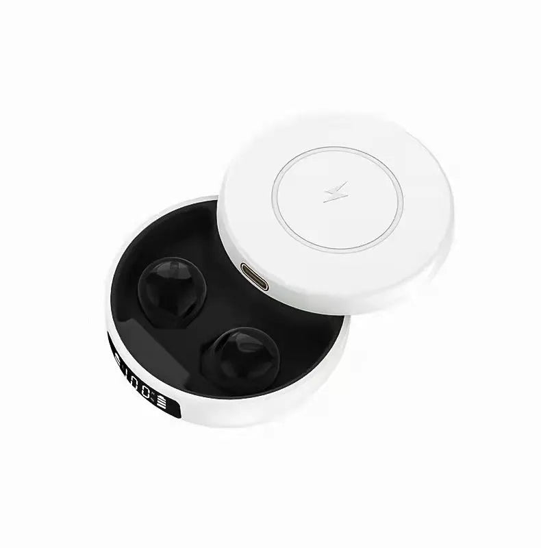 Mini black semi-in-ear wireless headphones sitting inside their white wireless charging case.