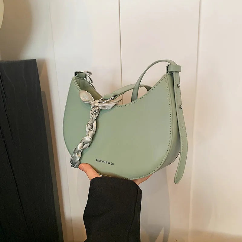 Small PU leather saddle bag on a flat surface, available in black, brown, coffee, green, khaki, and white