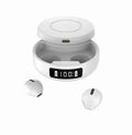 Mini black semi-in-ear wireless headphones sitting inside their white wireless charging case.