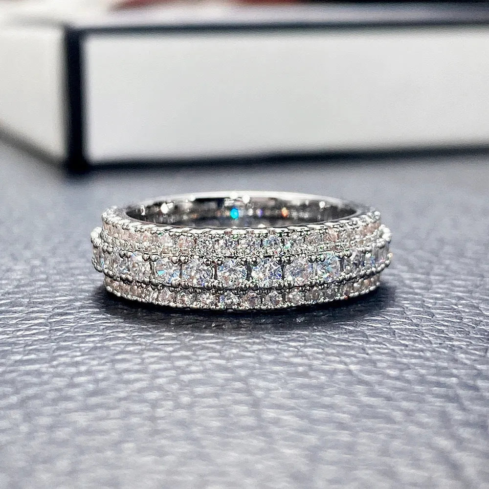 Geometric gang drill style engagement ring with a triangular zircon stone inlay on a metal band.