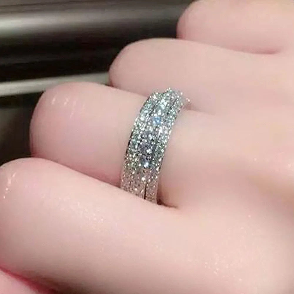 Geometric gang drill style engagement ring with a triangular zircon stone inlay on a metal band.