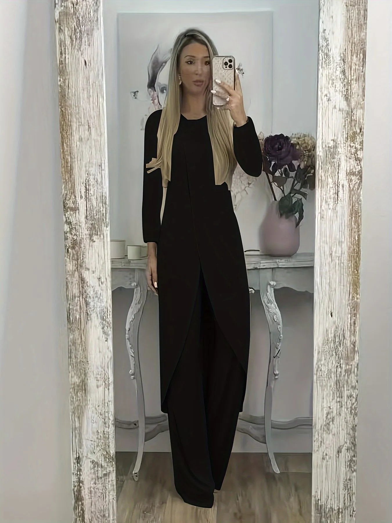 Man wearing a loose-fit black long sleeve top and matching trousers from a polyester two-piece lounge set.